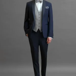 Smoking rever sciallato in sablè di lana blu abbinato 
a Gilet monopetto in seta jacquard